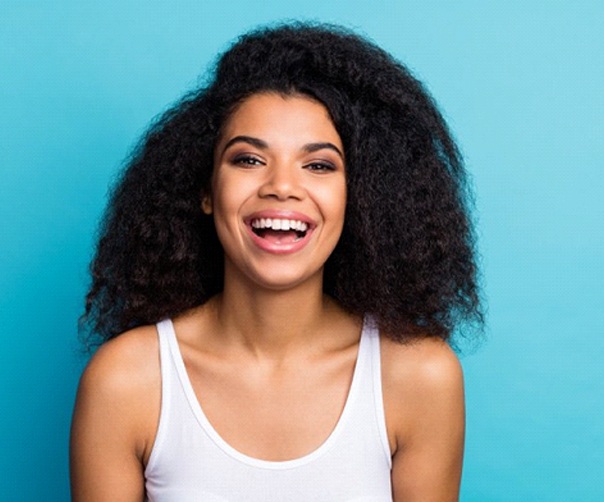 woman smiling with straight teeth thanks to Invisalign in Tyler, TX