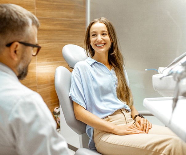 Patient and dentist smiling at each other during veneers appointment